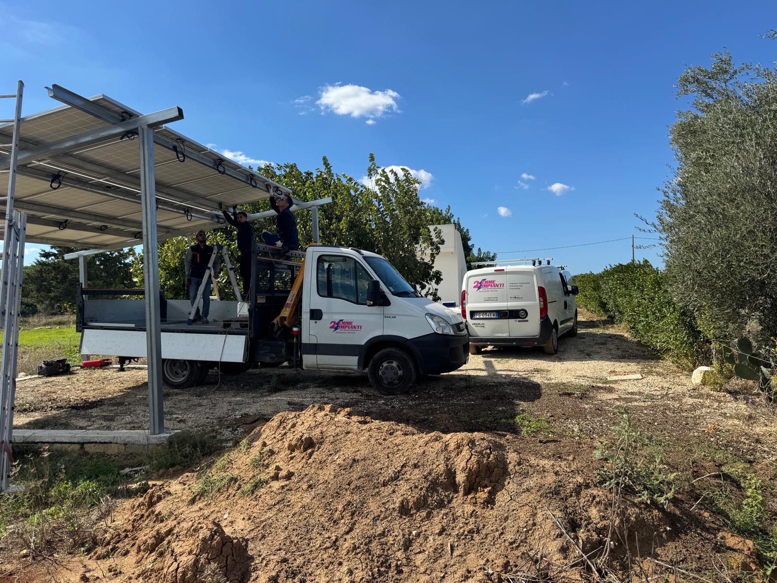 La squadra di 2 Emme Impianti al lavoro su una struttura fotovoltaica, con i mezzi aziendali